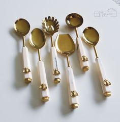 gold and white utensils are lined up on a table