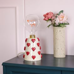 two vases with hearts are sitting on a table