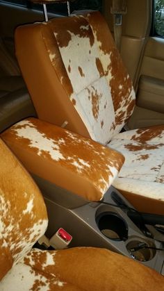 the interior of a car with brown and white spots on it's seat covers