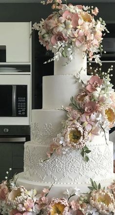 a white wedding cake with pink and yellow flowers on it