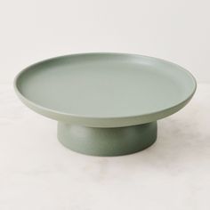 a green plate sitting on top of a white counter