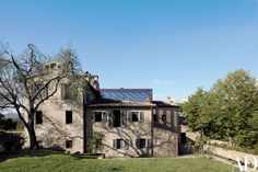 an old house with a solar panel on the roof is shown in this photo from across the yard