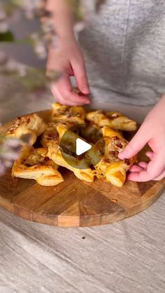 a person cutting up some food on top of a wooden board