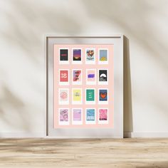 a white frame sitting on top of a wooden floor next to a wall filled with pictures