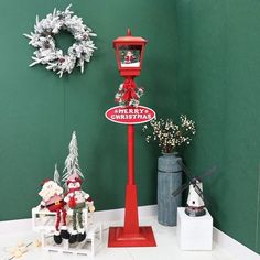 a red street sign sitting next to a christmas decoration