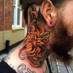 a man with a tattoo on his neck and behind the ear is an orange flower