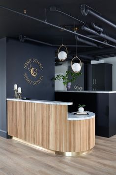 an office with black walls and white counter tops, gold accents on the front desk