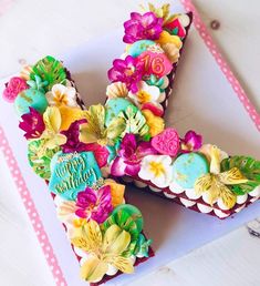 a decorated letter shaped cake sitting on top of a table