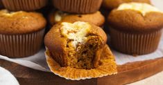 muffins with white frosting on a wooden tray