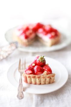 a strawberry tart on a plate with a fork