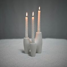 three white candles are in the shape of toothpicks