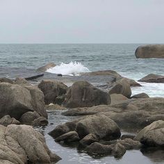 a person standing on rocks near the ocean