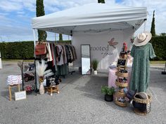 a tent with clothes and hats on display in the middle of an open parking lot