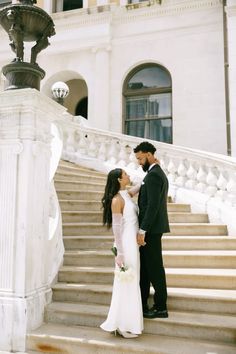 a bride and groom are standing on the stairs