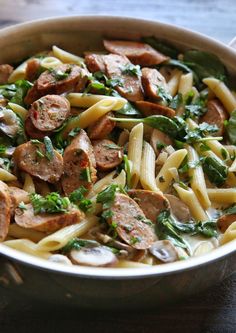 pasta with sausage, spinach and mushrooms in a pan