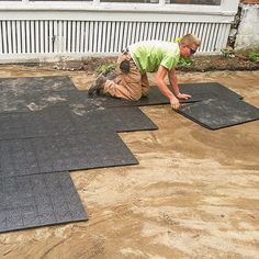 a man laying on the ground in front of some black mating and building materials