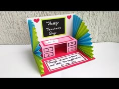 a handmade teacher's day card with an origami desk and chalkboard