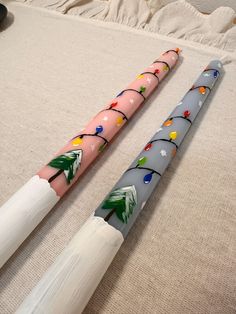 two colorful umbrellas sitting on top of a bed next to each other with christmas decorations painted on them