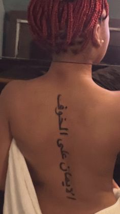 the back of a woman's body with writing on her upper and lower back