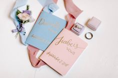 wedding rings, ring box and personalized notebooks laid out on top of each other