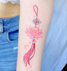 a woman with a tattoo on her arm holding a pink flower and tatoo