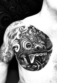 a man's chest with an intricate tattoo design on it