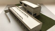 an architectural model of a building with grass on the ground next to it and a ramp