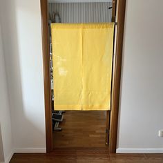 an open door with a yellow towel hanging from it's side in a room