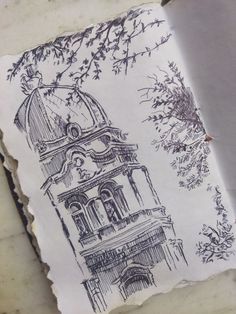 a piece of paper with a drawing of a clock tower on it's side