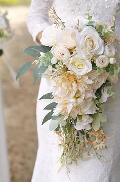 a bride holding a bouquet of white flowers