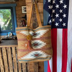 an american flag hanging on the wall next to a bag with a tassel in it