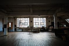 an empty room with lots of windows and furniture on the floor in front of them