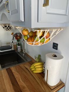 some fruit is in a basket on the kitchen counter