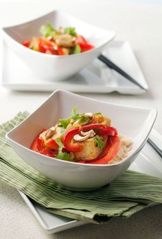 two white bowls filled with food on top of a table