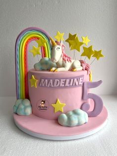 there is a cake that looks like a coffee cup with unicorns on it and stars