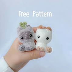 two small crocheted stuffed animals sitting on top of each other's fingers