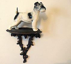 a black and white dog figurine sitting on top of a wall mounted shelf