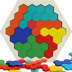 a wooden puzzle with different colored shapes and colors on the surface, including one in the middle