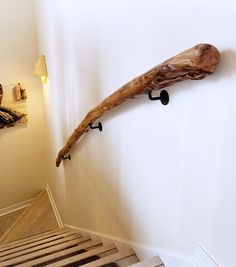 a wooden object hanging on the wall next to a stair case