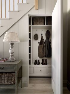 the entryway is decorated in white and features an understaffed coat rack with baskets on it