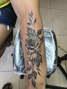 a woman's arm with a rose tattoo on it