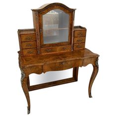 an old wooden desk with a mirror on it's top and drawers below the table