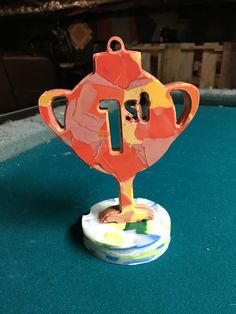 an orange trophy sitting on top of a green table