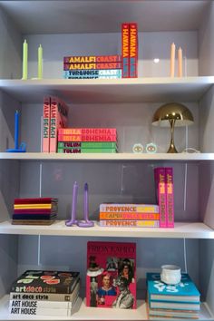 the shelves are filled with books and candles