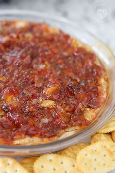 a pizza and crackers on a plate with sauce in the middle, ready to be eaten