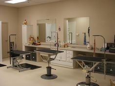 an empty room with mirrors, sinks and hair dryers on the counter top in front of them