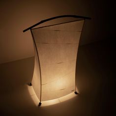 a light that is on in the dark with some kind of paper hanging from it's side