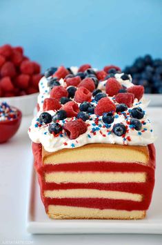 a red, white and blue cake is on a plate with berries in the background