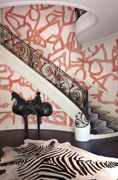 a zebra rug in front of a staircase with red graffiti on the wall behind it