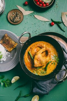 some food is sitting in a pan on a table with other plates and utensils